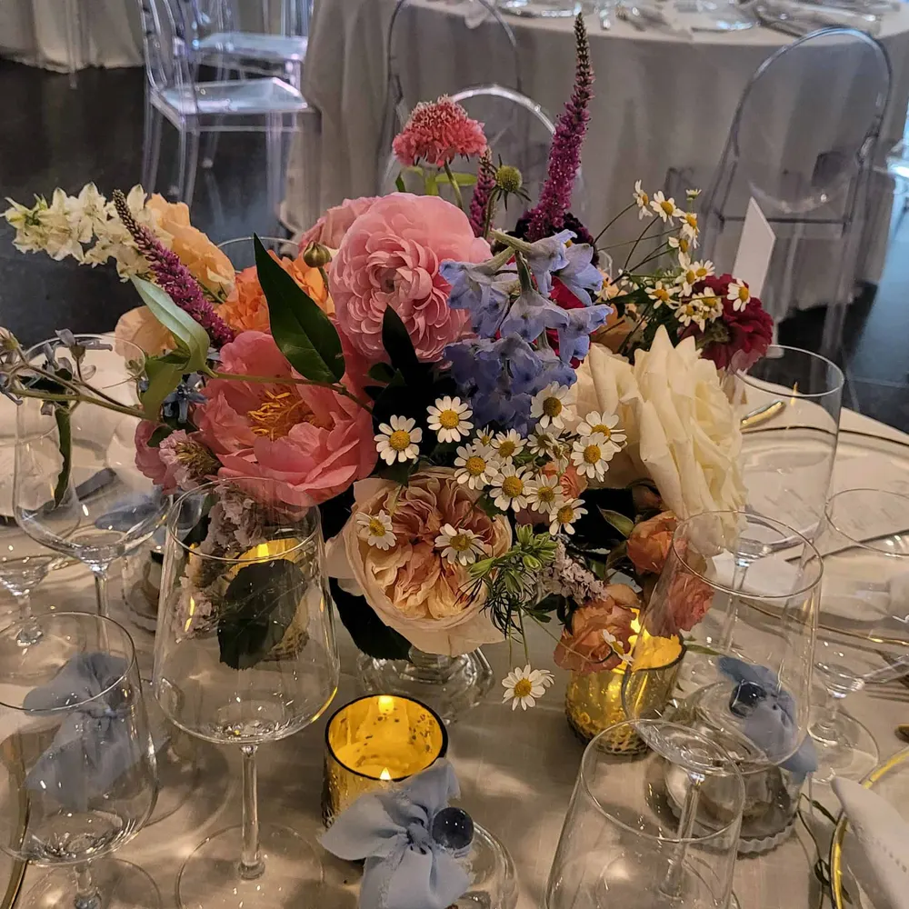 Colorful low centerpiece with coral peonies and daisies