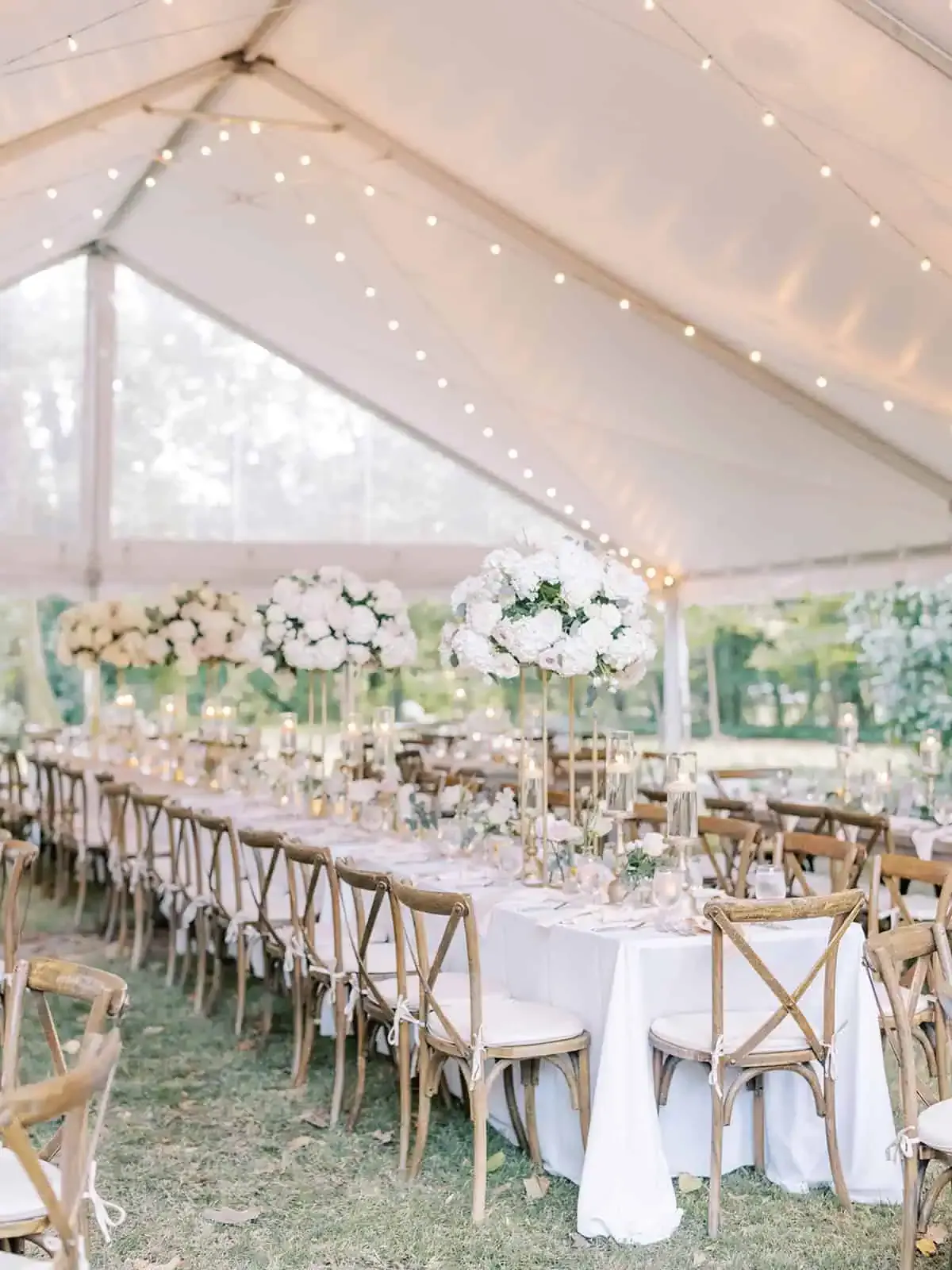 Tented wedding reception with tall white centerpieces