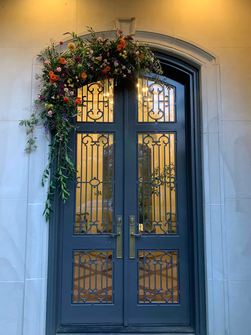 Floral swag above a front door with iron gates