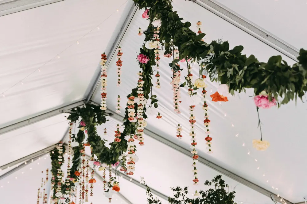 Hanging garland strands with blooms inside a tent