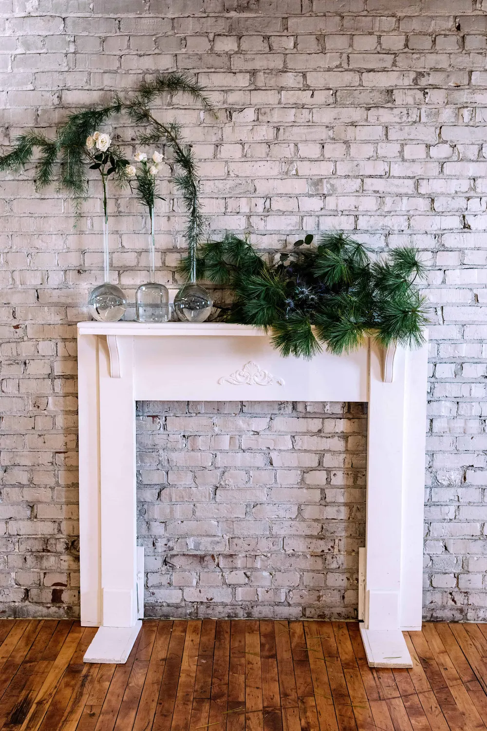 Evergreen garland on a white brick mantel